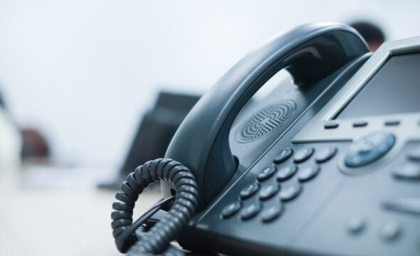 close up soft focus on telephone devices at office desk for customer service support concept